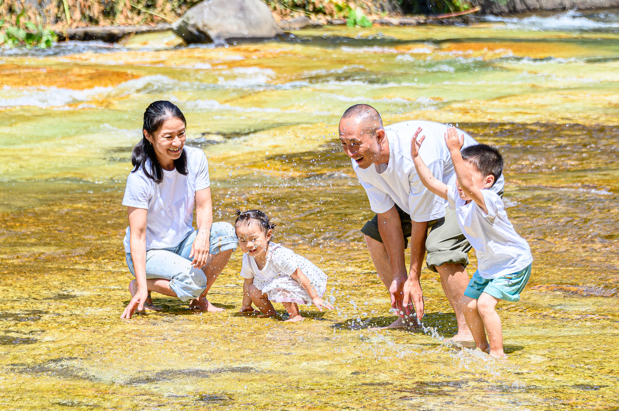 白絹の床で水遊びをする家族